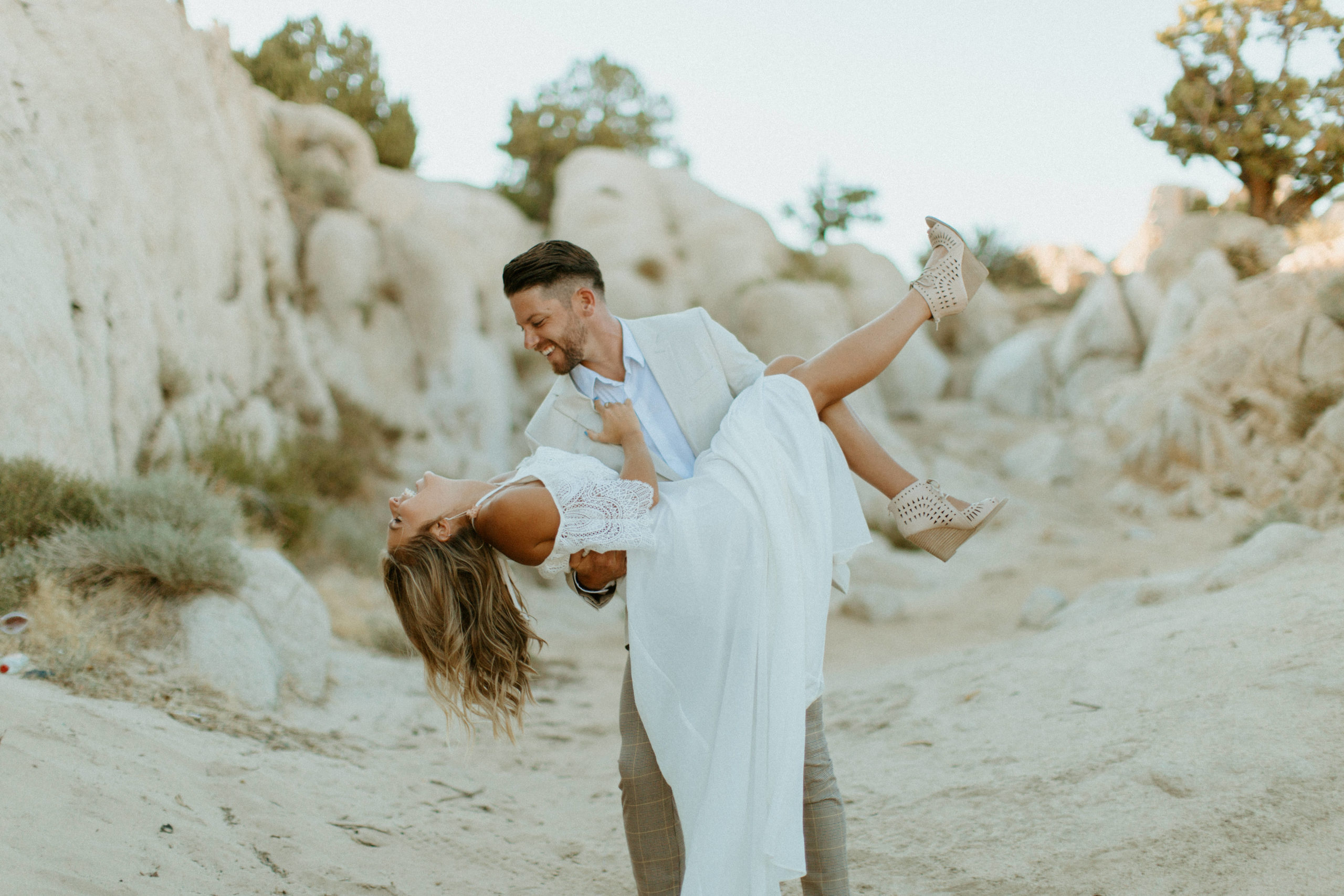 Reno Wedding Photographer captures groom carrying bride and laughing