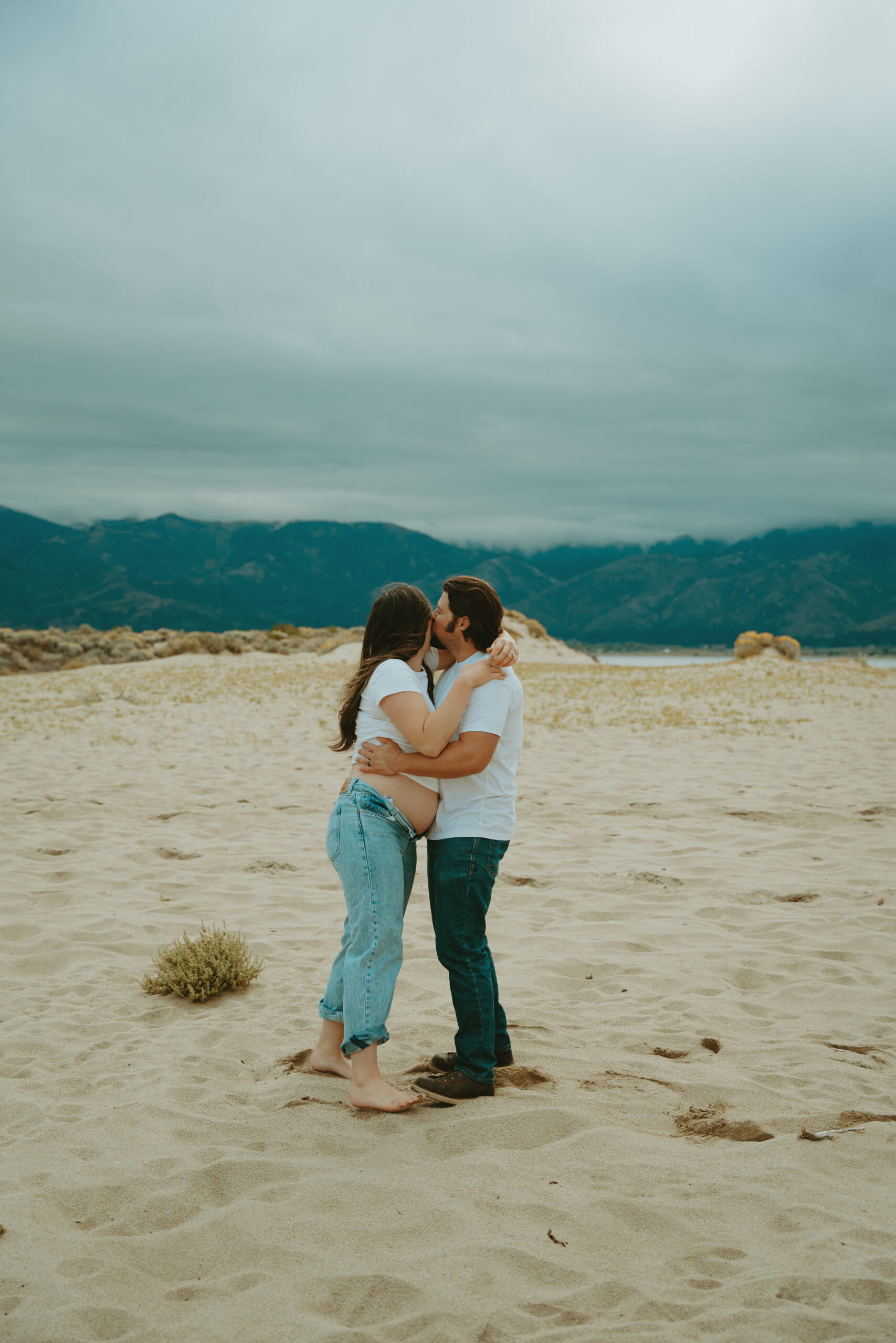 A maternity photoshoot, set amidst the stunning blue-green Nevada Mountains and golden-brown Washoe Valley fields, evokes nostalgia. The simplicity of the overall aesthetic lends a charmingly rustic yet romantic ambiance to every moment shared between the couple.