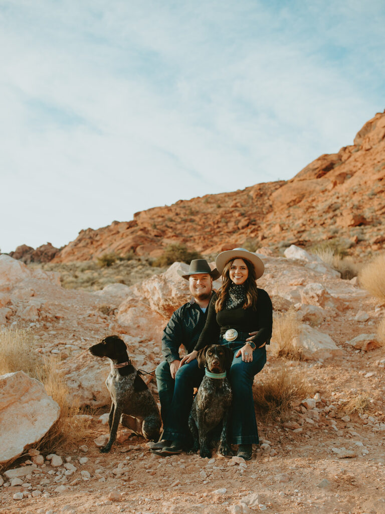 Wedding Photographers Reno capture couple sitting together with pups at Red Rocks