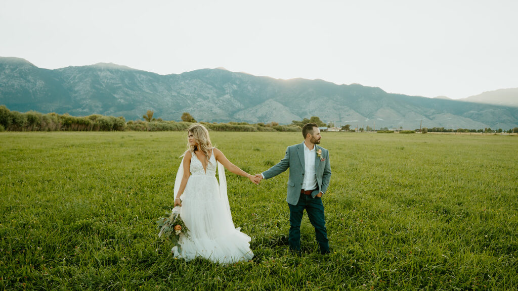 Reno wedding photographer captures bride and groom holding hands on wedding day while looking in opposite directions