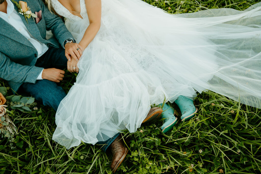 Reno wedding photographer captures bride and groom sitting in grass after western wedding