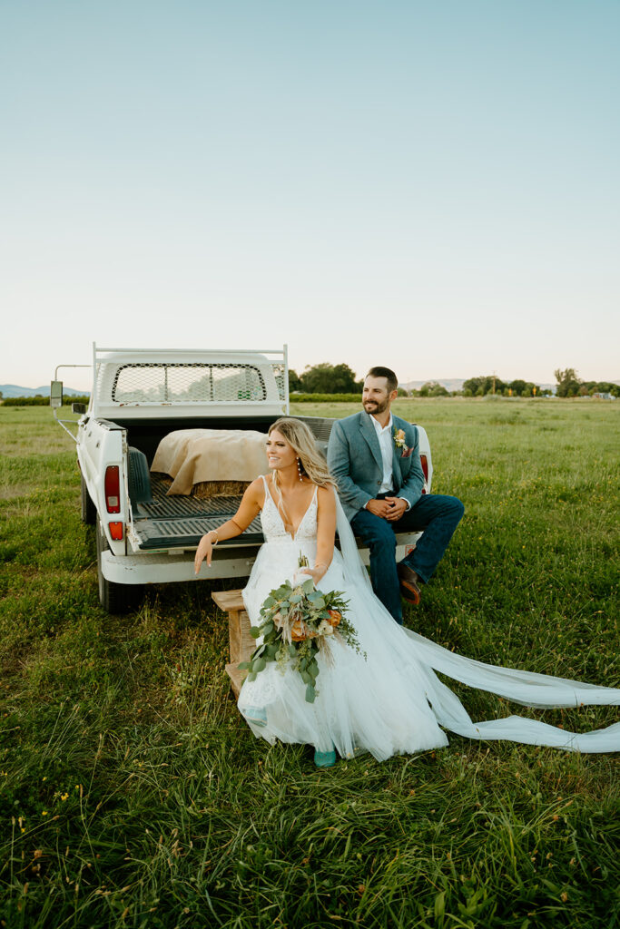 Reno wedding photographer captures bride and groom sitting on truck bed after western wedding ceremony