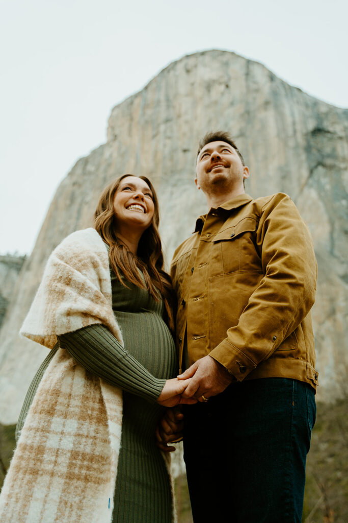 Yosemite wedding photographer captures couple holding hands looking up at landscape in Yosemite