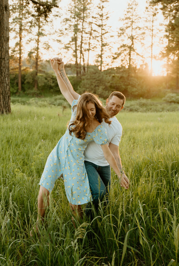 Reno wedding photographer captures man and woman playing together in field during spring engagement photos