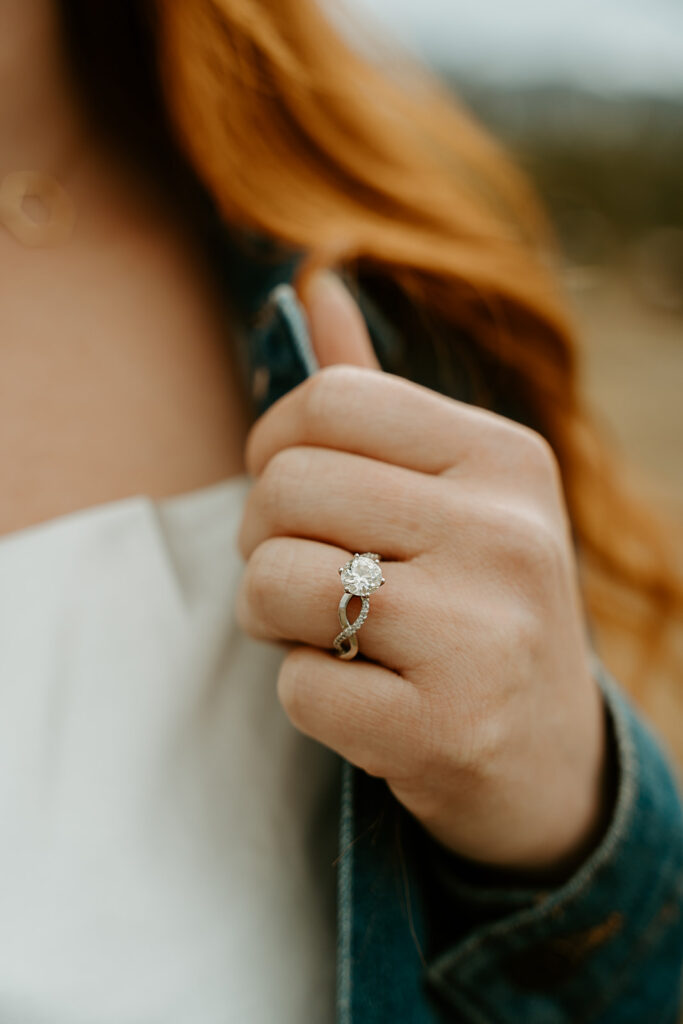 Reno wedding photographer captures woman wearing engagement ring while holding jean jacket