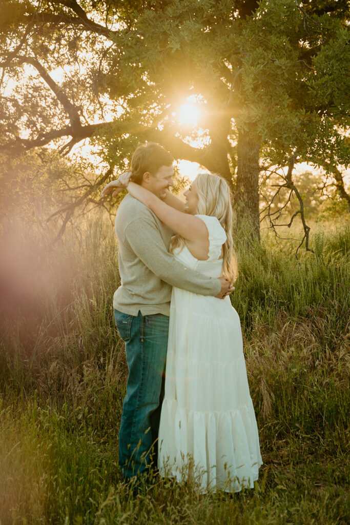 Reno wedding photographer captures woman wrapping arms around fiance's neck during golden hour