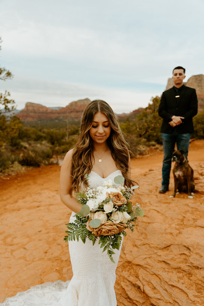 Wedding Photographers Reno capture bride holding bouquet while groom looks on