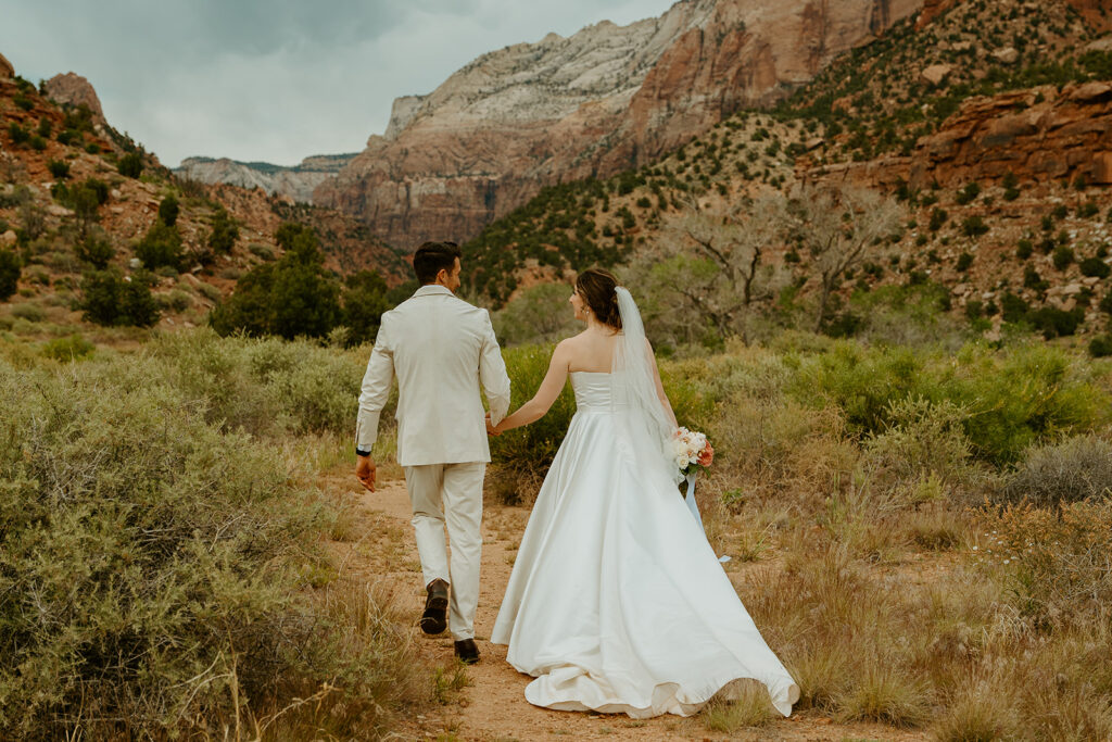 Destination Wedding Photographer captures bride and groom walking through national park